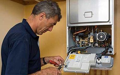 technicien-chauffagiste-paris-13-effectuant-une-maintenance-de-chaudiere